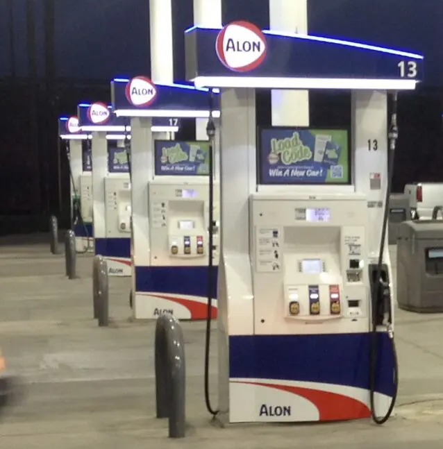 Gas station pumps at night, Alon brand.