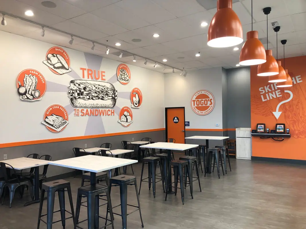 Modern sandwich shop interior with orange accents.