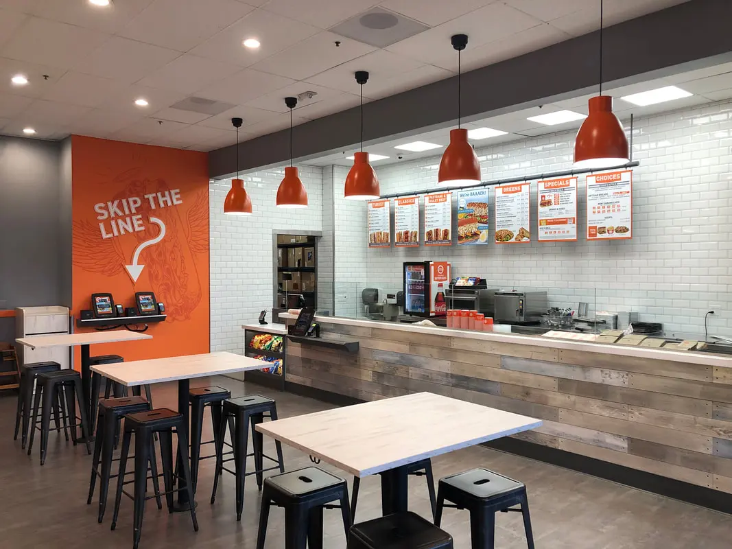 Fast food restaurant interior with ordering kiosks.