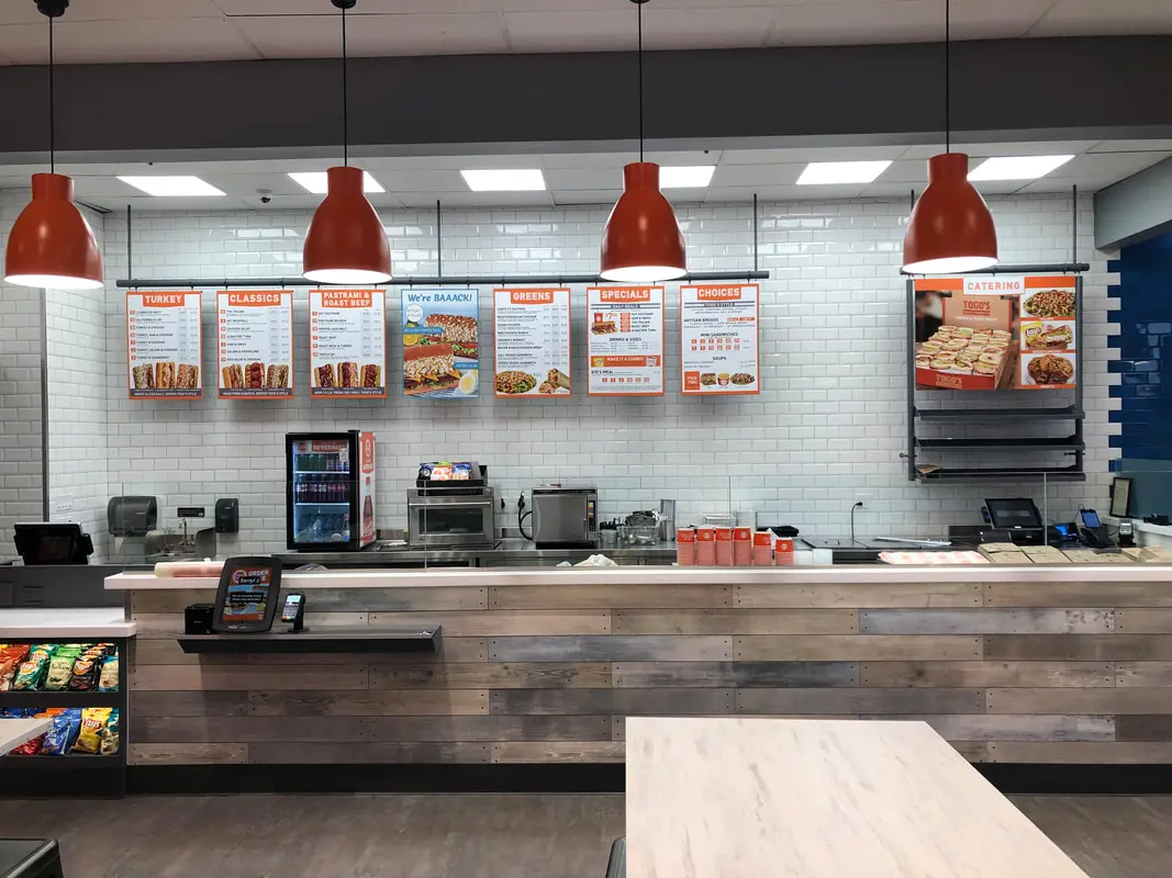 Fast food restaurant counter with menu displays.